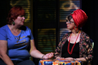 A red headed woman talking to a psychic with a red turban on her head