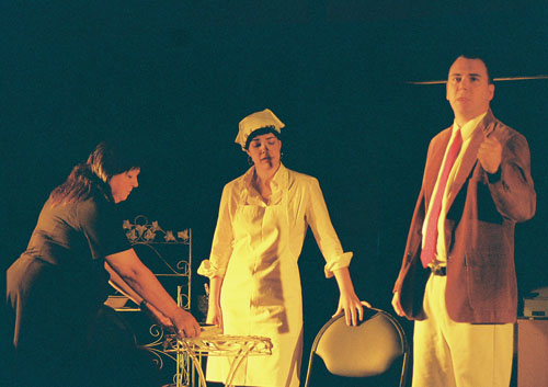 Two women, one in an apron, and a man in a coat