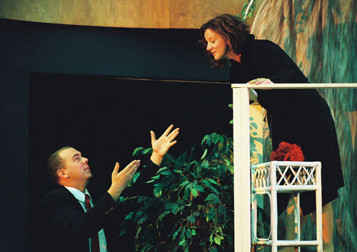 A man talking to a woman on a balcony