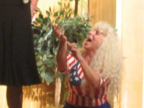 A woman in a red, white and blue outfit kneeling and pointing at her hand