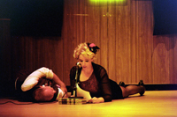 A woman lying on the floor talking into a microphone, with a man lying next to her