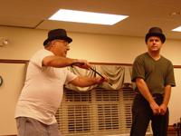 Two men with top hats and canes rehearsing a dance