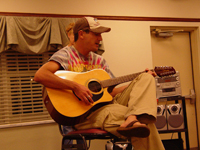 A man sitting and playing a guitar