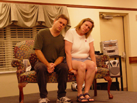 A man and a woman sitting together with their heads tilted to the right