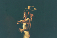 A woman pointing and a man in a cowboy hat looking at her