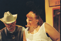 A woman talking to a man in a cowboy hat