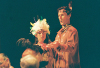 A Native American girl wearing a headdress and a Native American man standing next to her