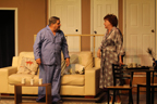 A man and woman in pajamas standing in front of a couch